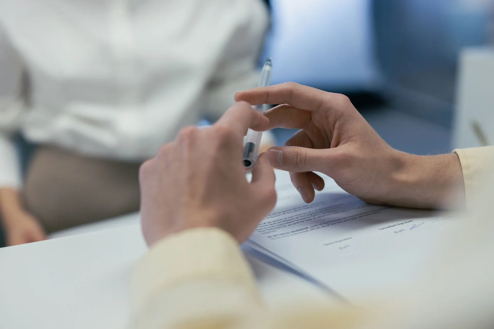 Hand holding a pen over a document