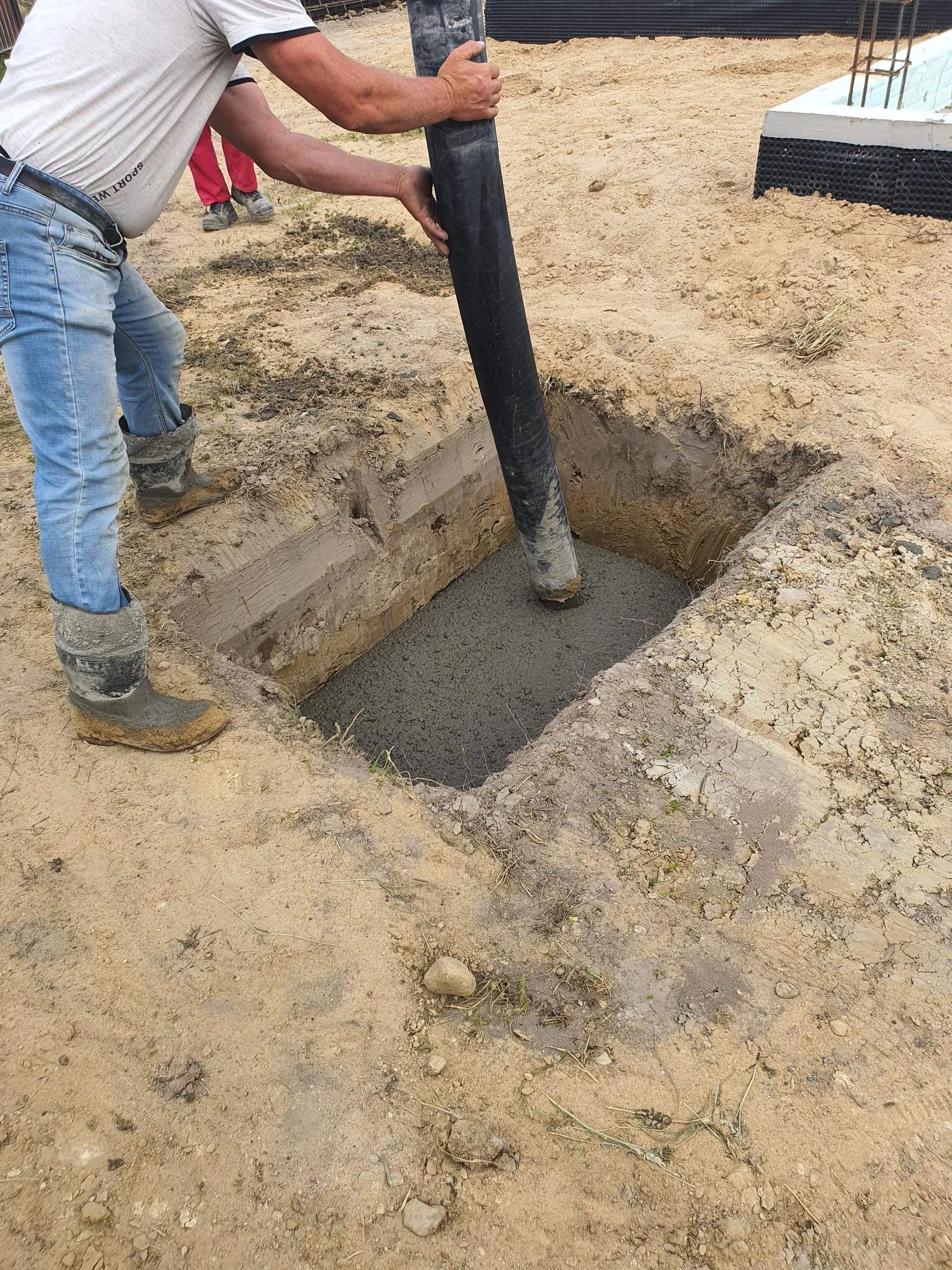 Worker pouring concrete on site