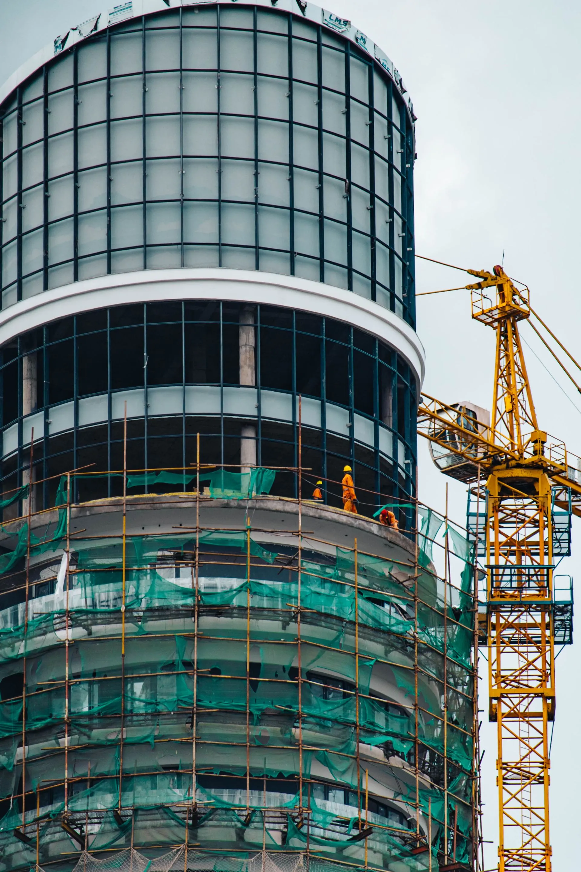 Workers in high-visibility gear at a steel frame site