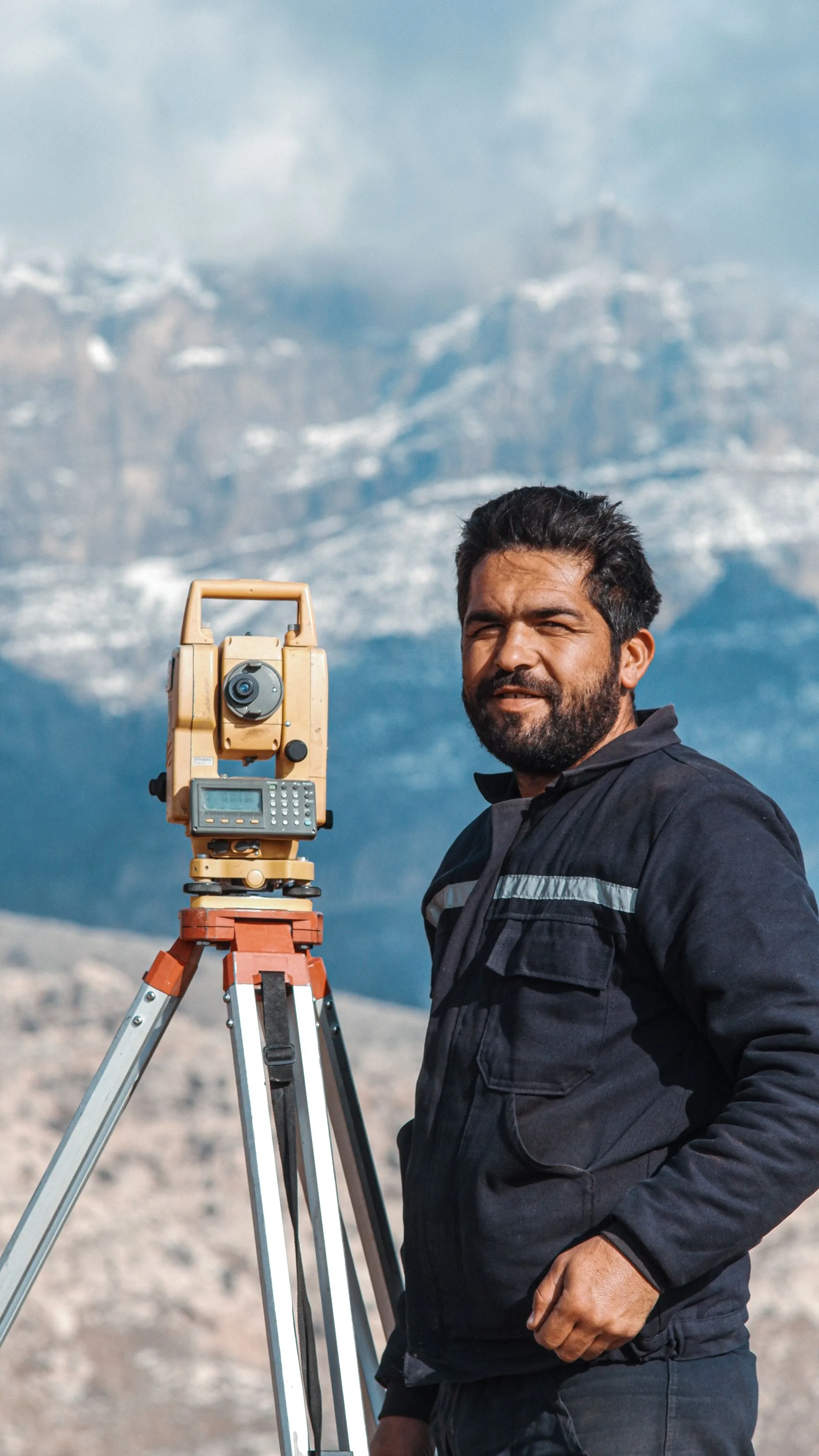 Surveyor operating a theodolite in the field