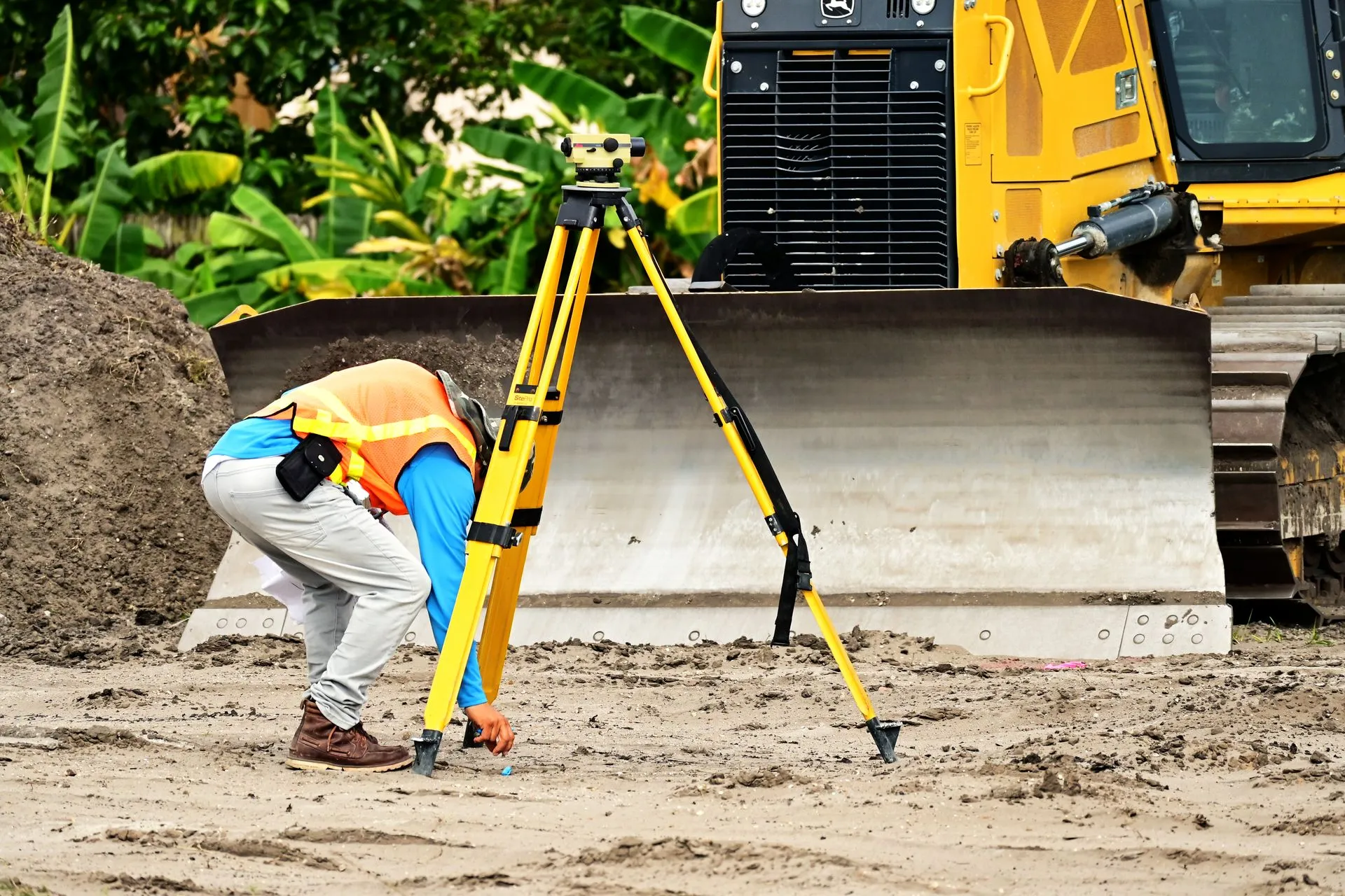 Surveyor operating a total station on site